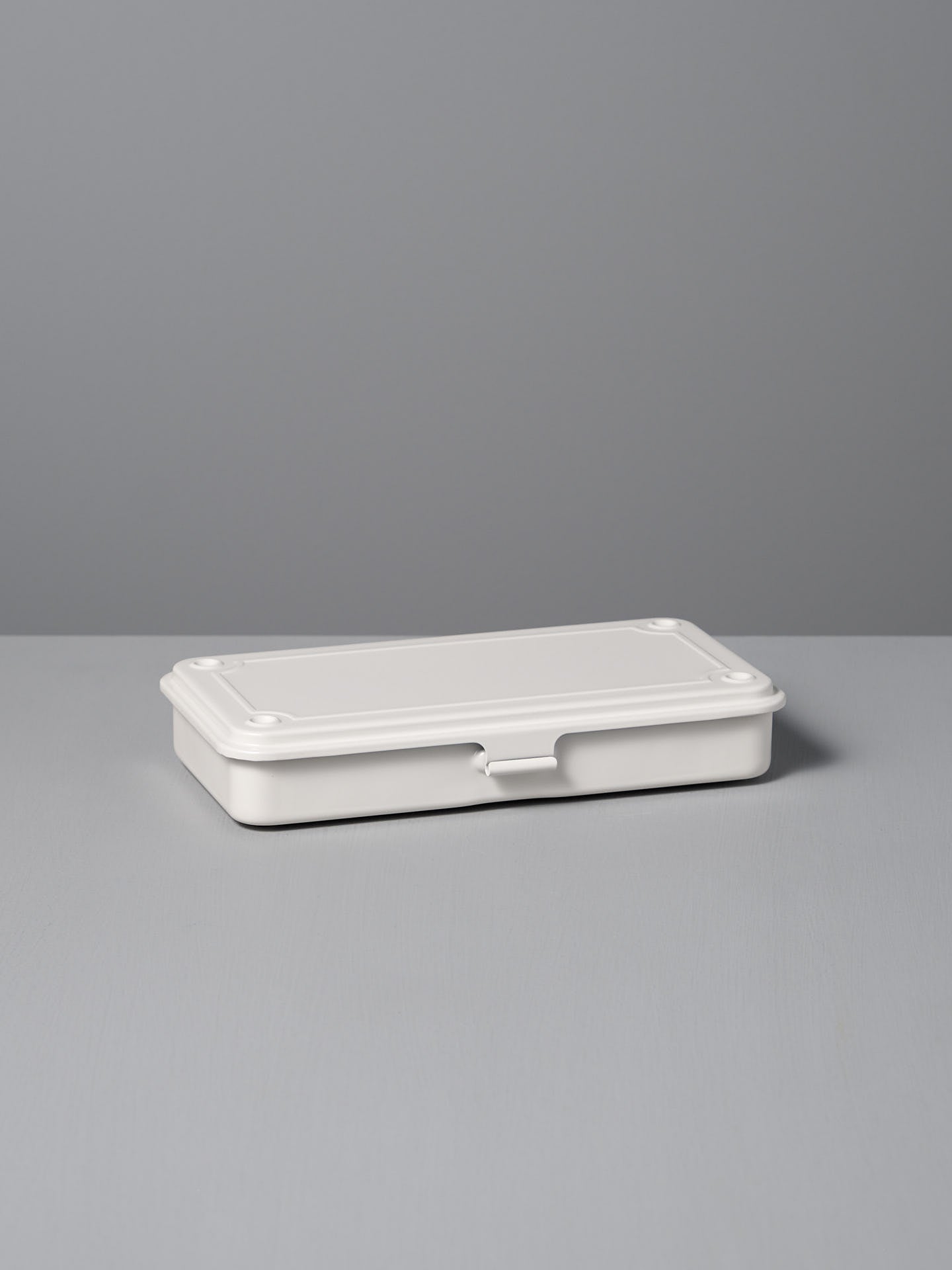 The TOYO STEEL Mini Steel Toolbox T-192 in white, expertly crafted from powder-coated steel, rests on a gray surface.