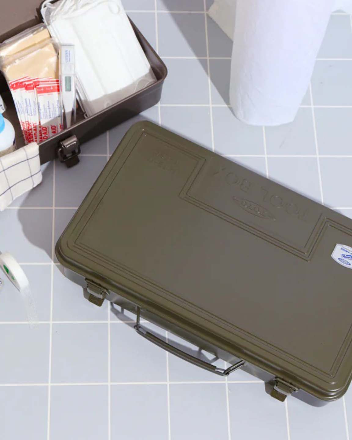 The Trunk-style Toolbox T-360 in moss green, a closed rectangular metal box with handle and two latches for practical storage, is set on a plain surface against a neutral background.