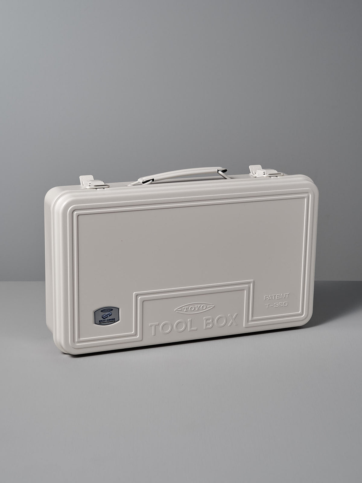 The Trunk-style Toolbox T-360 – White by TOYO STEEL, made from powder-coated steel and featuring an embossed &quot;TOOL BOX&quot; with a patent number, offers an excellent storage solution set against a gray background.