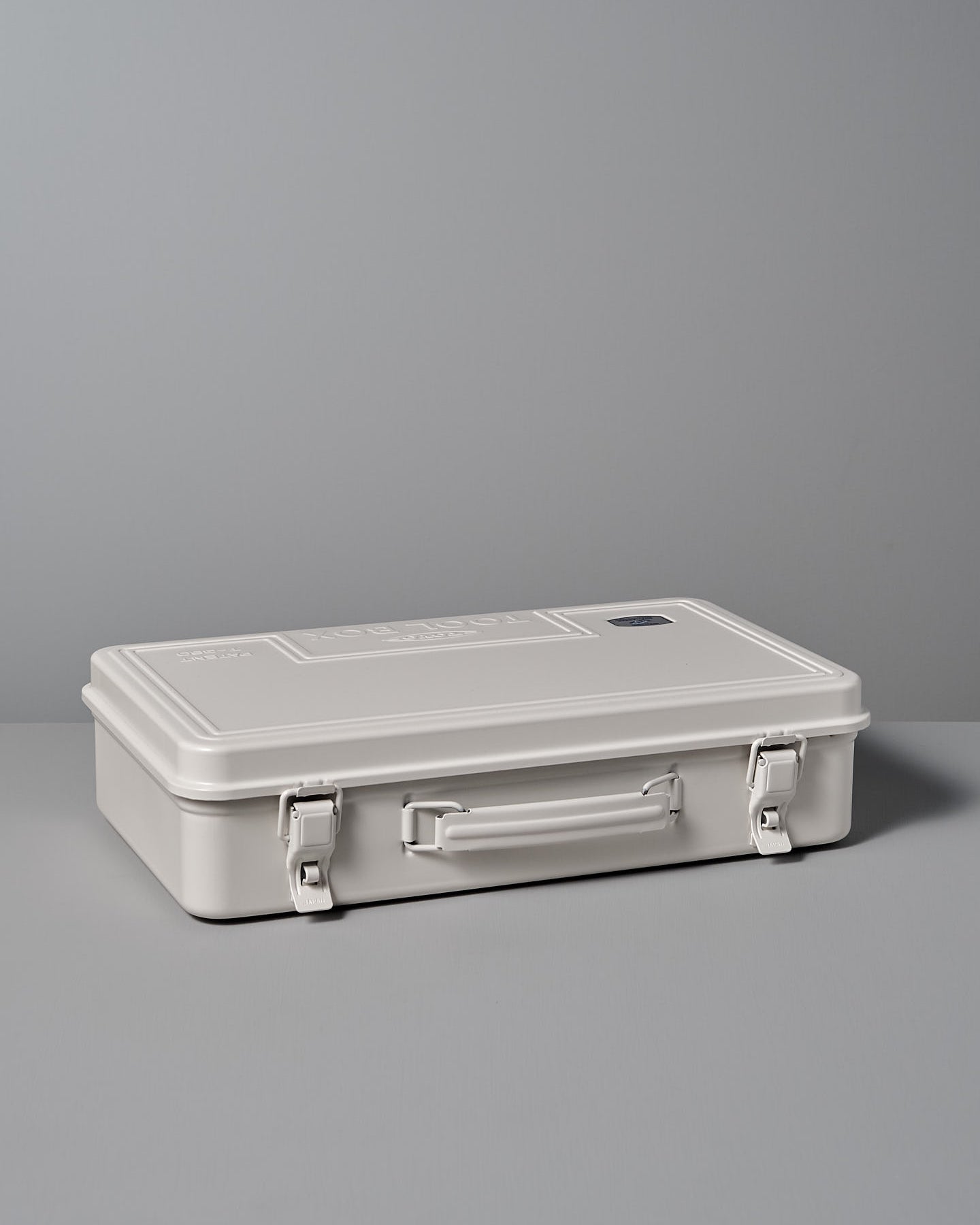 The Trunk-style Toolbox T-360 – White by TOYO STEEL, made from powder-coated steel and featuring an embossed "TOOL BOX" with a patent number, offers an excellent storage solution set against a gray background.