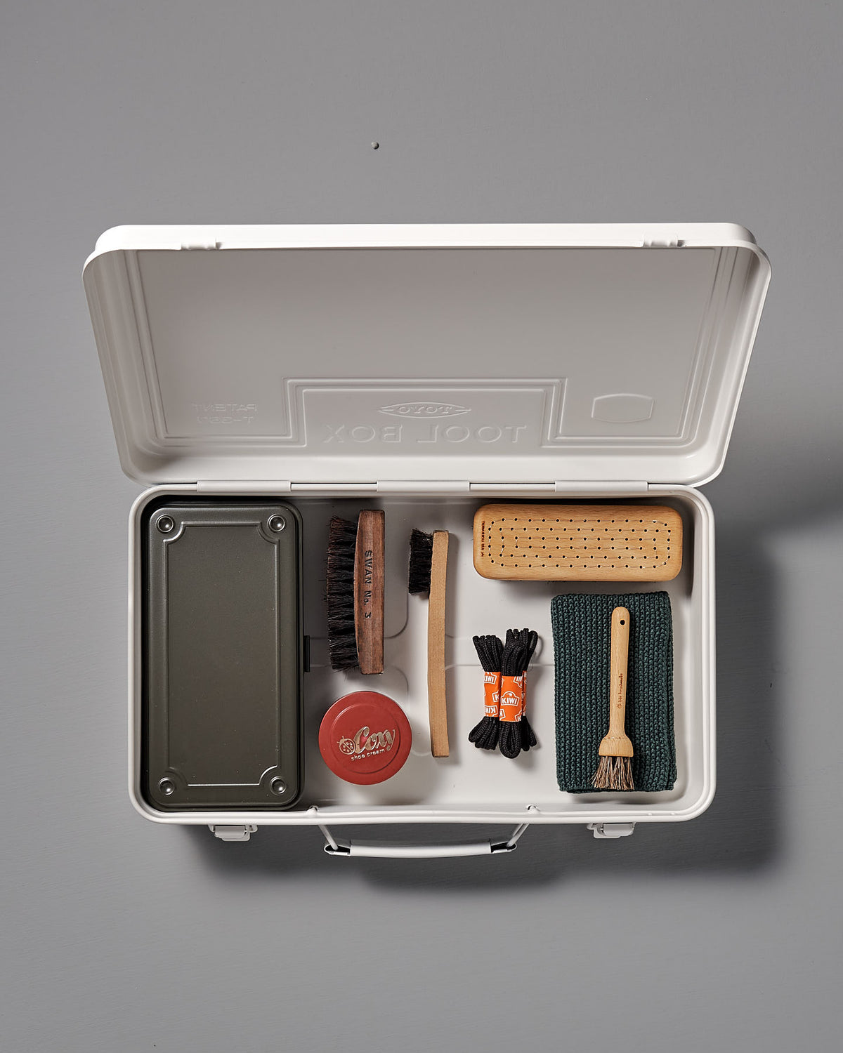 The Trunk-style Toolbox T-360 – White by TOYO STEEL is a sleek storage solution that neatly organizes shoe care essentials such as brushes, a cloth, a polish tin, and a sponge. Sturdy and versatile like a toolbox, it ensures everything is in its place.