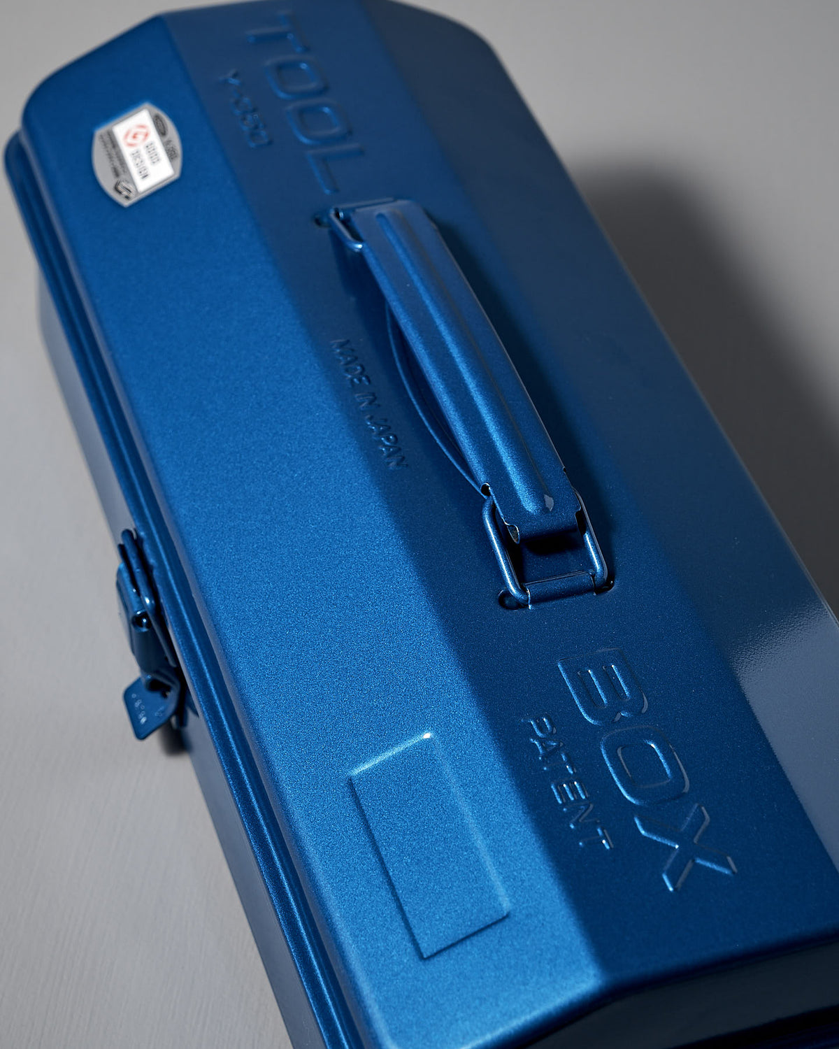 The Camber-Top Toolbox Y-350 from TOYO STEEL is a blue, powder-coated steel toolbox with a closed, cambered top design, featuring an embossed brand name and a convenient handle on top.