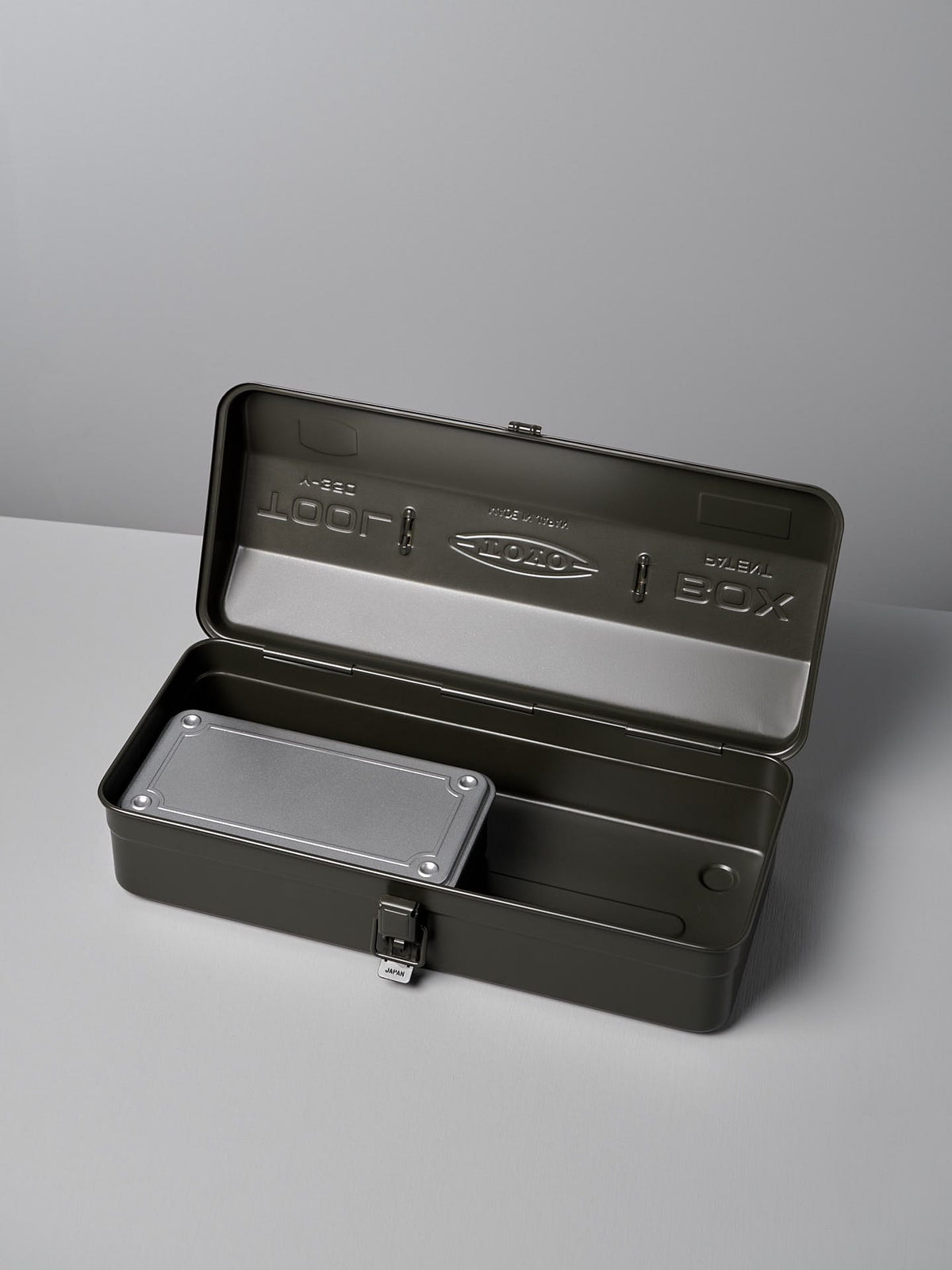 An open dark gray metal toolbox with a hinged lid, showcasing an inner tray and a built-in lock at the front. The Camber-Top Toolbox Y-350 – Moss Green by TOYO STEEL won the Good Design Award 2009, ensuring both durability and style in your workshop.