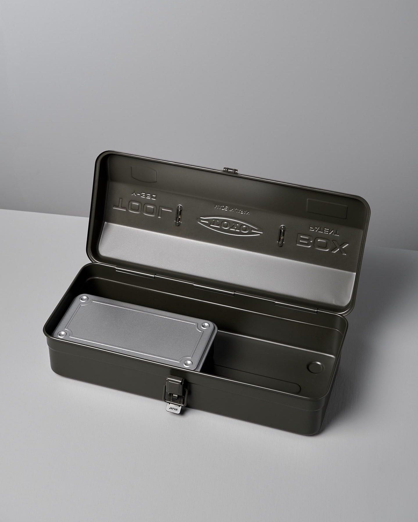 A closed, rectangular, dark green metal Camber-Top Toolbox Y-350 – Moss Green made by TOYO STEEL in Japan with a handle and a latch, sits on a light grey surface.