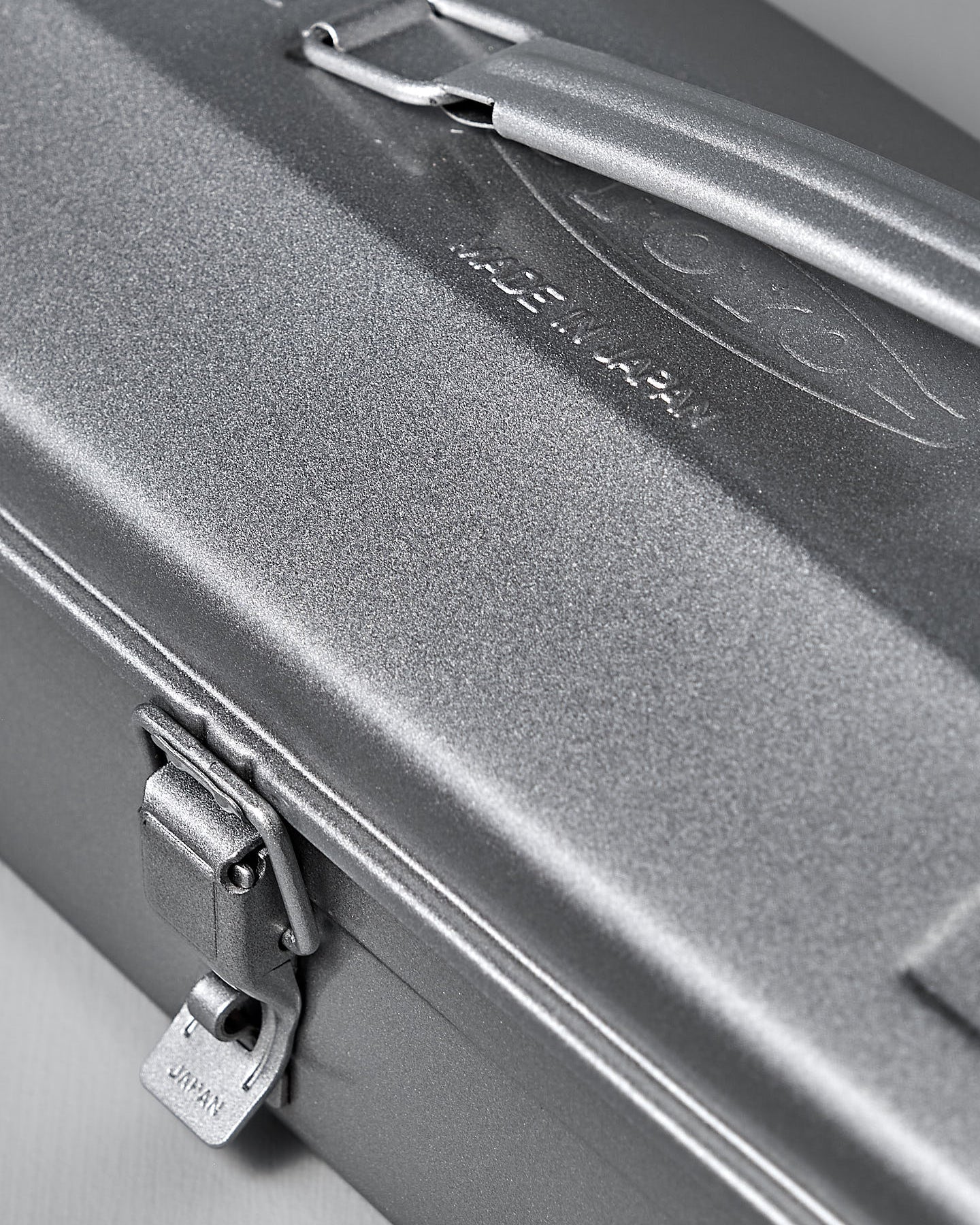 The TOYO STEEL Camber-Top Toolbox Y-350 in powder-coated silver elegantly rests on a gray surface, blending with the matching background.
