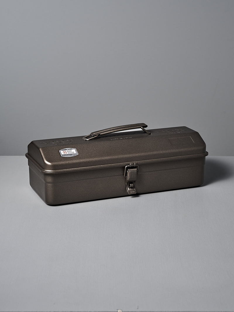 The TOYO STEEL Camber-Top Toolbox Y-350 – Titanium, made from powder-coated steel with a secure latch and sturdy handle, elegantly rests on a flat surface against a plain backdrop, embodying the Good Design Award 2009 standards.