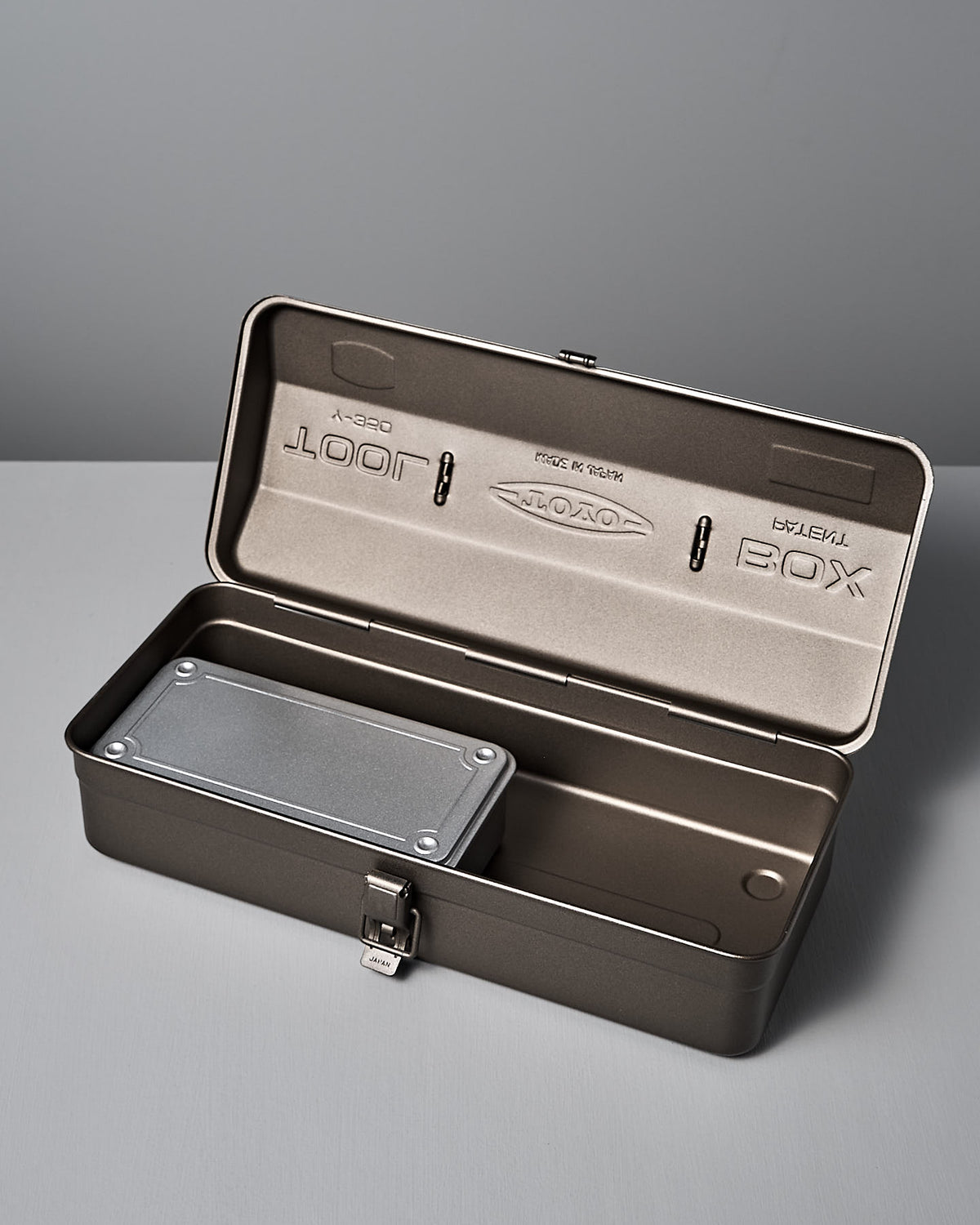 The Camber-Top Toolbox Y-350 – Titanium by TOYO STEEL is crafted from powder-coated steel with an open gray design and rectangular compartment. Set on a matching surface, this elegant toolbox won the Good Design Award 2009.