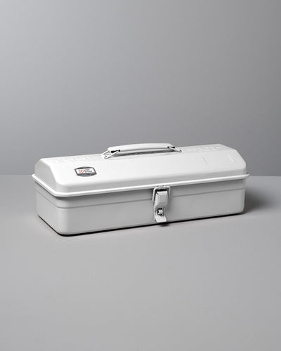 The TOYO STEEL Camber-Top Toolbox Y-350 in white, made from powder-coated steel, features a handle and latch and is displayed gracefully on a gray surface.