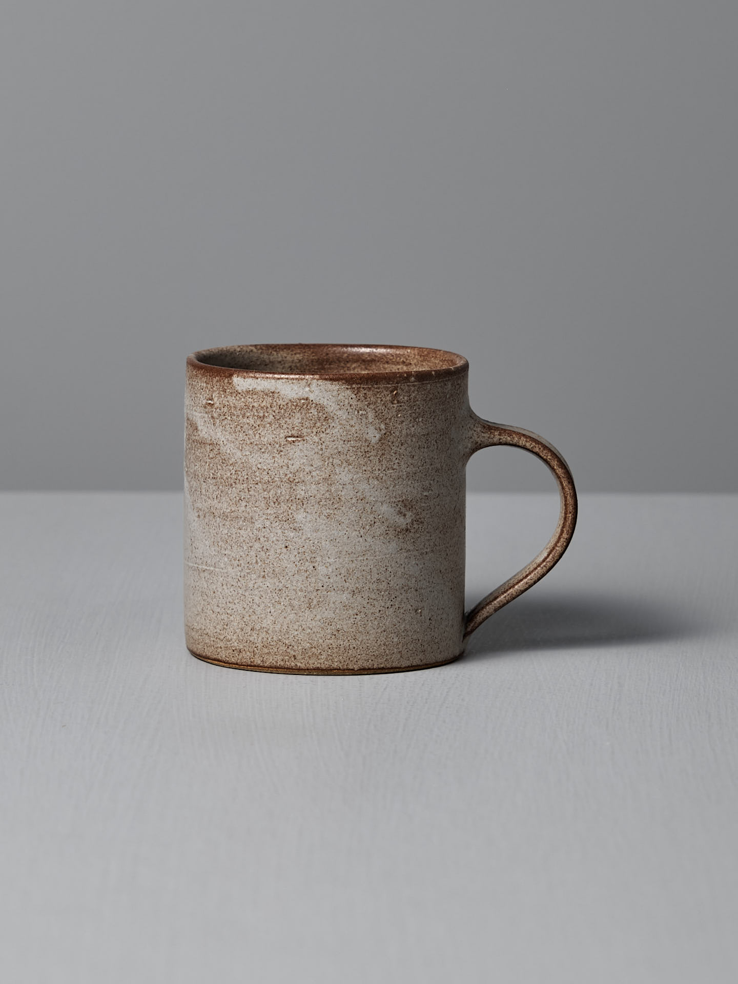 The Zoë Isaacs Coffee Cup – Blue Grey is displayed on a light gray surface with a plain gray background.