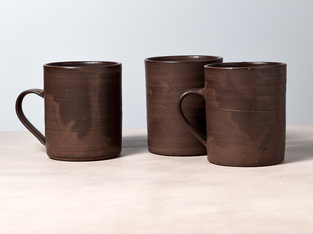 Three Zoë Isaacs brown mugs sitting on a table.