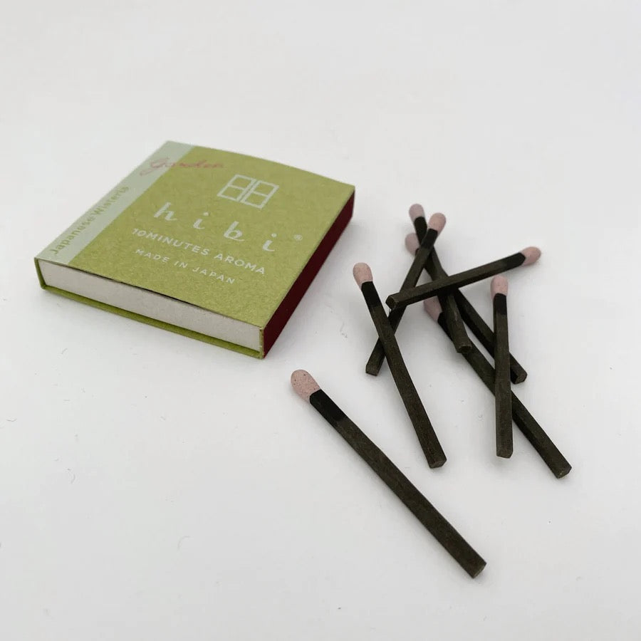 hibi Match Box Incense Garden – Peony and a book on a white surface.