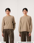 Side-by-side images show a woman wearing the Nimbus Raglan Knit – Truffle with brown pants; the left features a Petite fit, while the right displays a relaxed fit matching set.