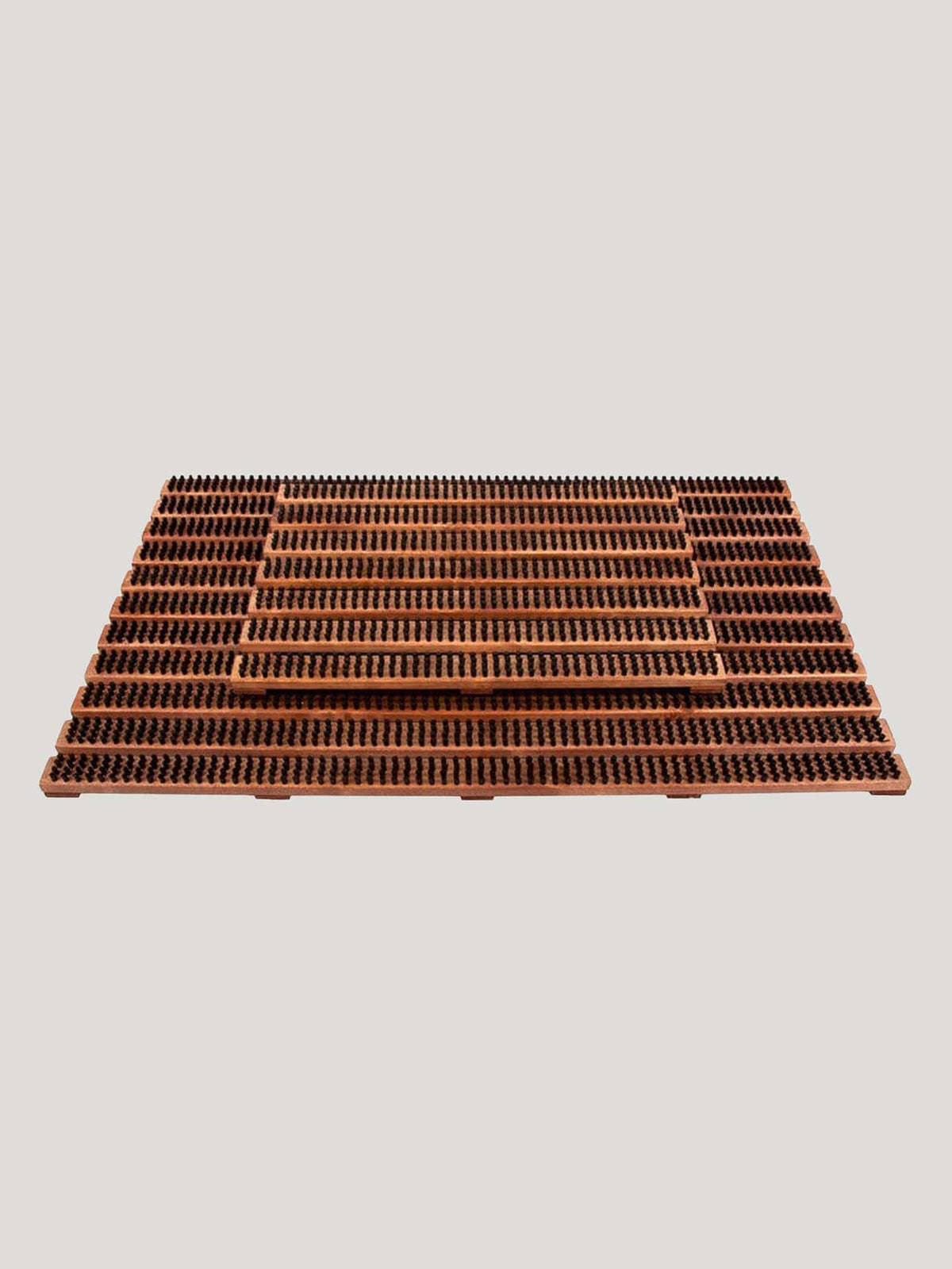 The Wooden Doormat with Bristles – Large by Iris Hantverk is a brown grooved rectangular mat with evenly spaced ridges, offering a durable design and quick-drying capabilities.