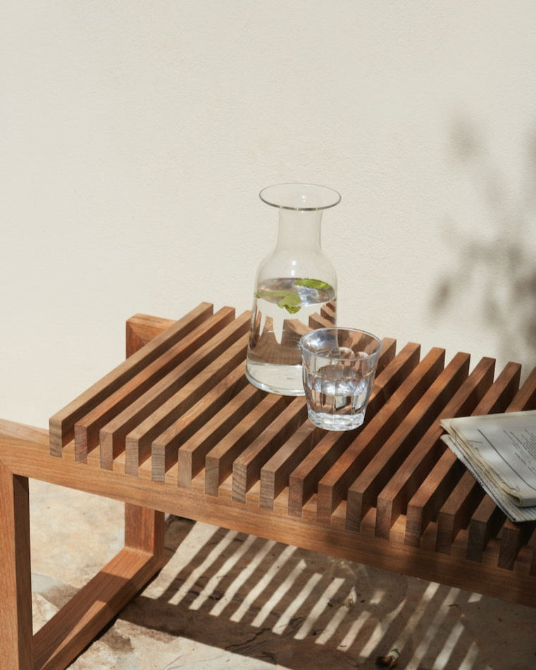 A Skagerak Hammer Decanter with a glass of water on it.