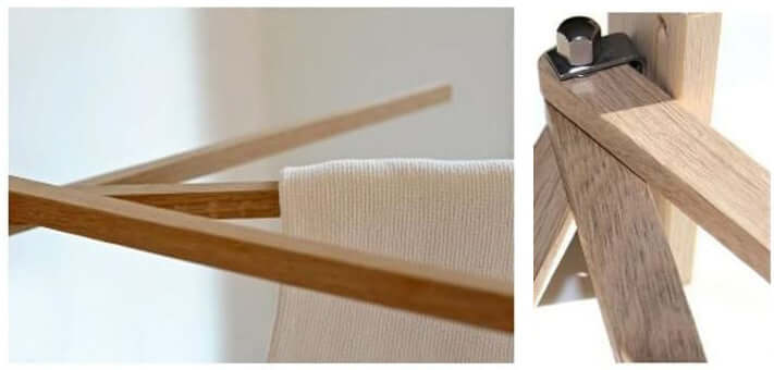 A wooden clothes rack with a towel hanging on it.