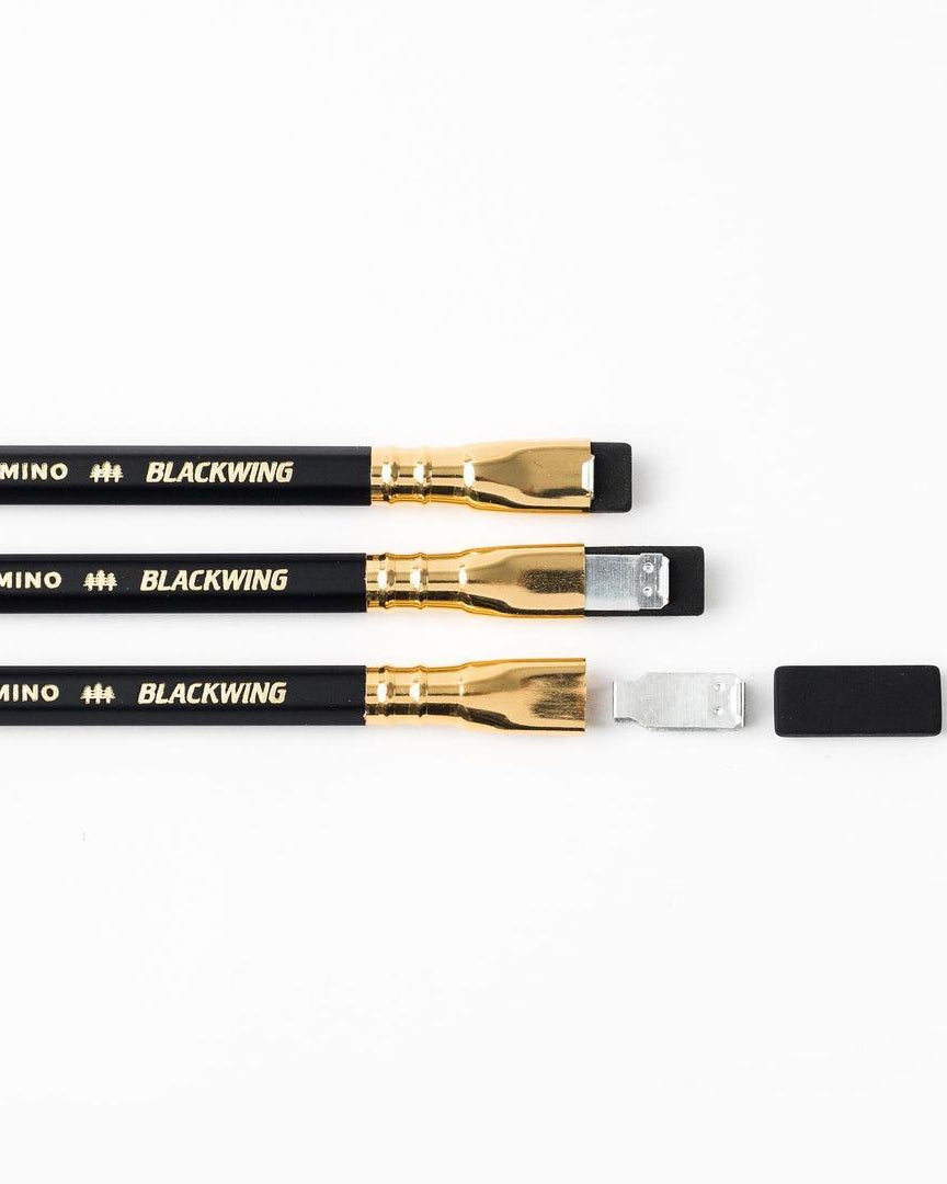 A pack of Palomino Blackwing Replacement Eraser 10pk – White ⋄ Black ⋄ Pink, designed with a dust-free design, displayed on a wooden surface.