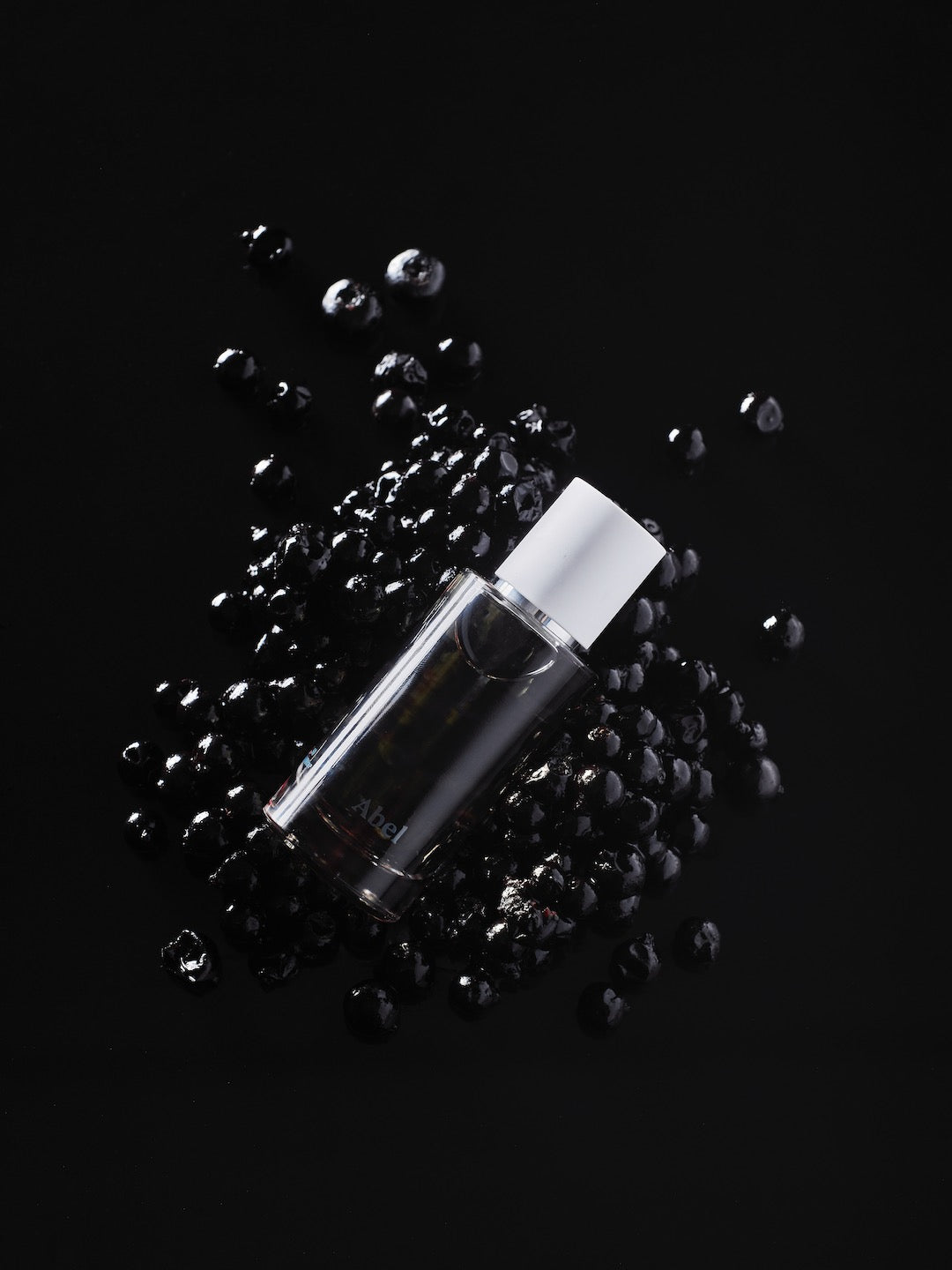 A bottle of Black Anise oil by Abel on a smoky black background.