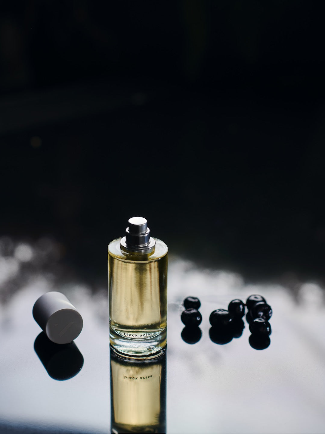 A sultry, long-lasting Black Anise – a vibrant, smoky amber perfume bottle on a table. (Brand Name: Abel)