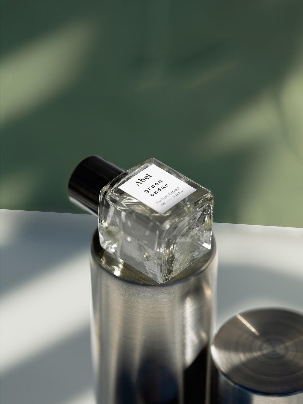 A bottle of Green Cedar Parfum Extrait – for vitality by Abel sitting on top of a table.
