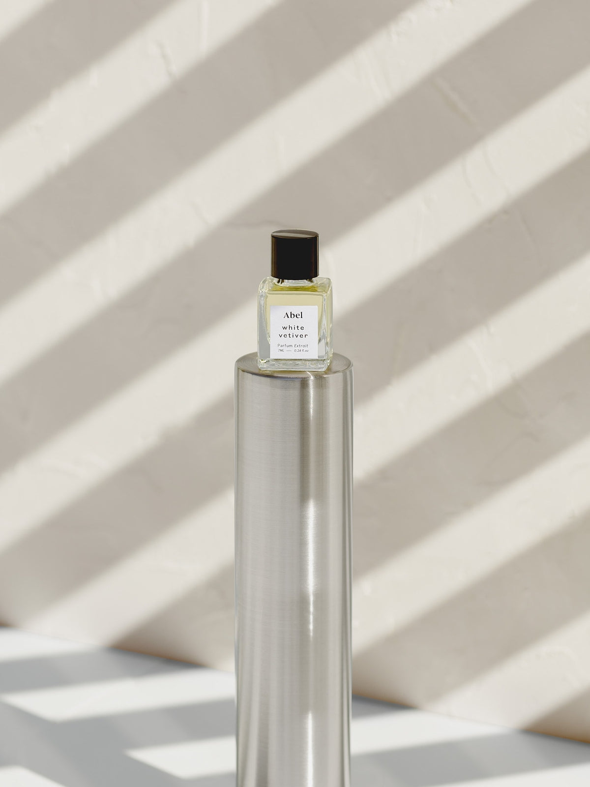 An Abel White Vetiver Parfum Extrait – for energy, an alcohol-free bottle of therapeutic-grade essential oils used for scent rituals, sitting on top of a table.