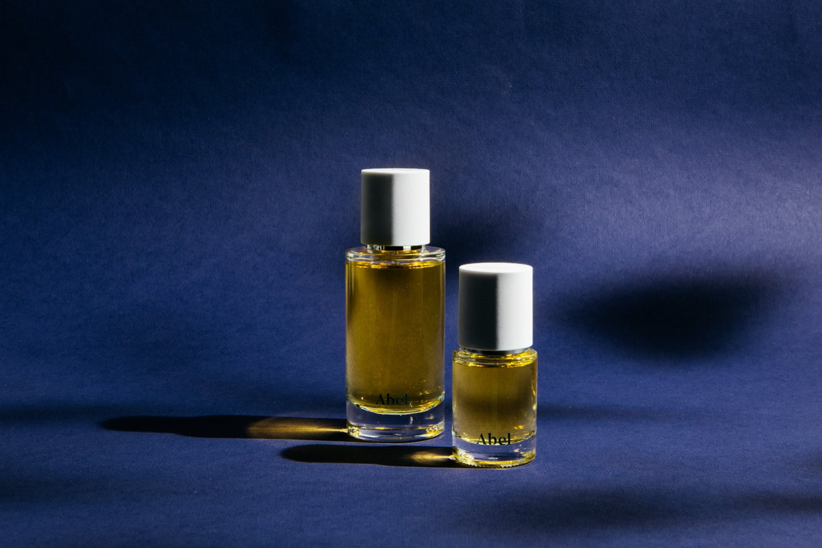 Two bottles of Cobalt Amber – a chic, sultry oriental by Abel on a blue background.