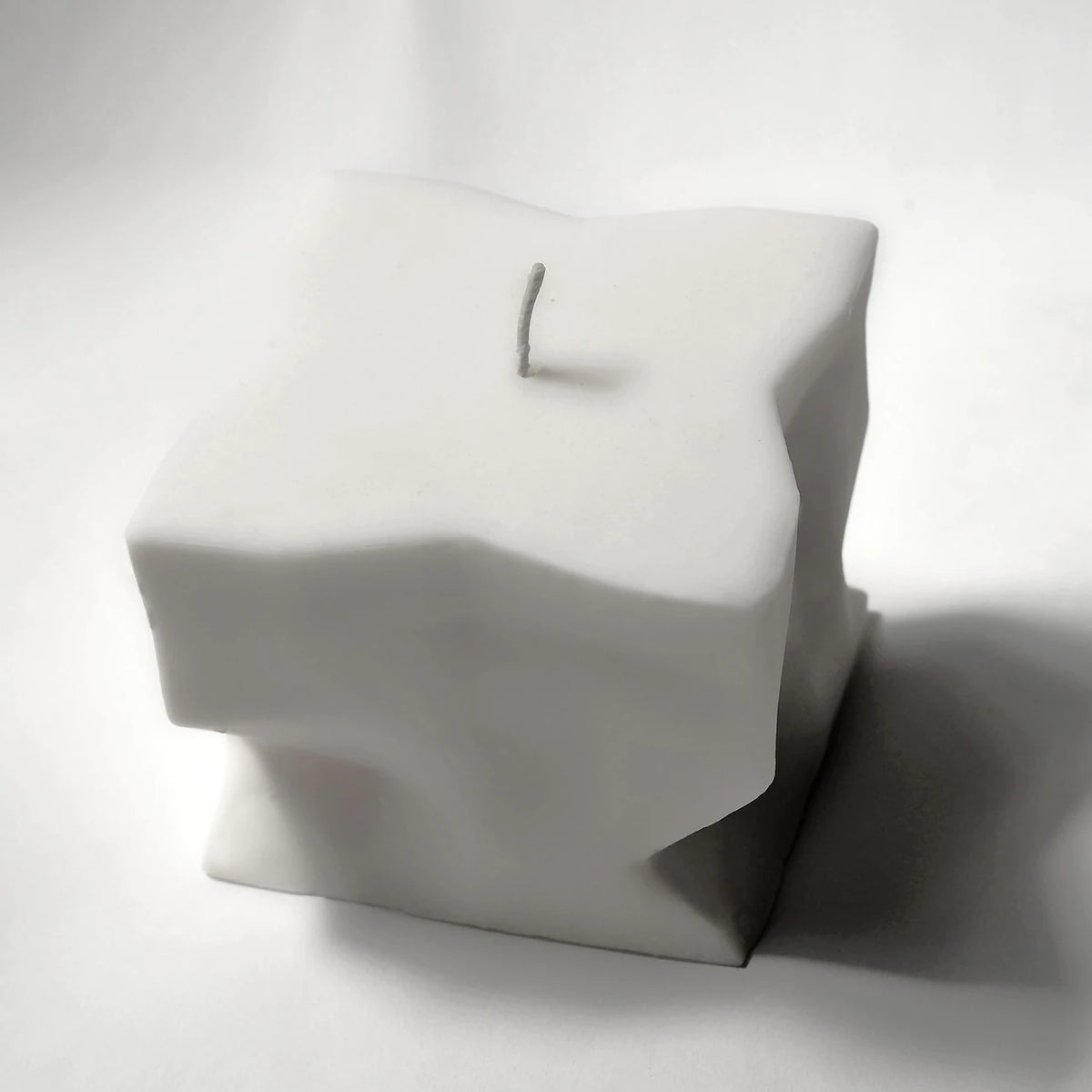 A Baltazar Candle by Andrej Urem is sitting on a white surface.