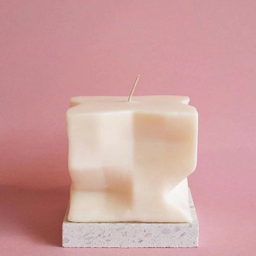 A Baltazar Candle from the Andrej Urem brand sitting on top of a pink background.