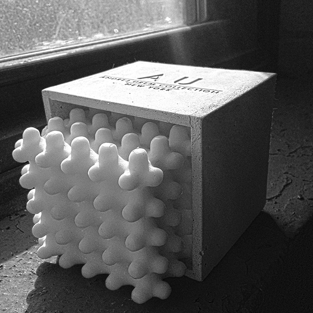 An Andrej Urem Lace Candle sitting on a window sill.