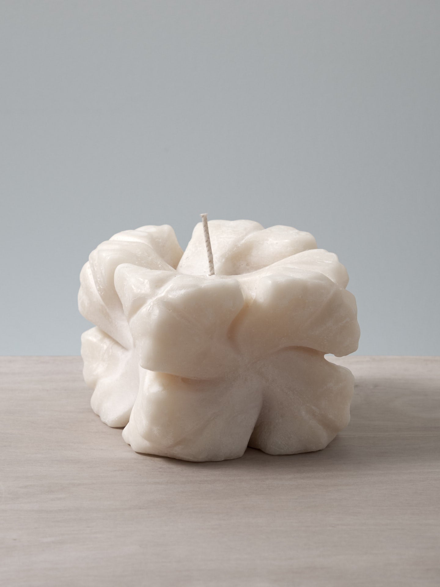 An Andrej Urem Rose Candle sitting on top of a table.