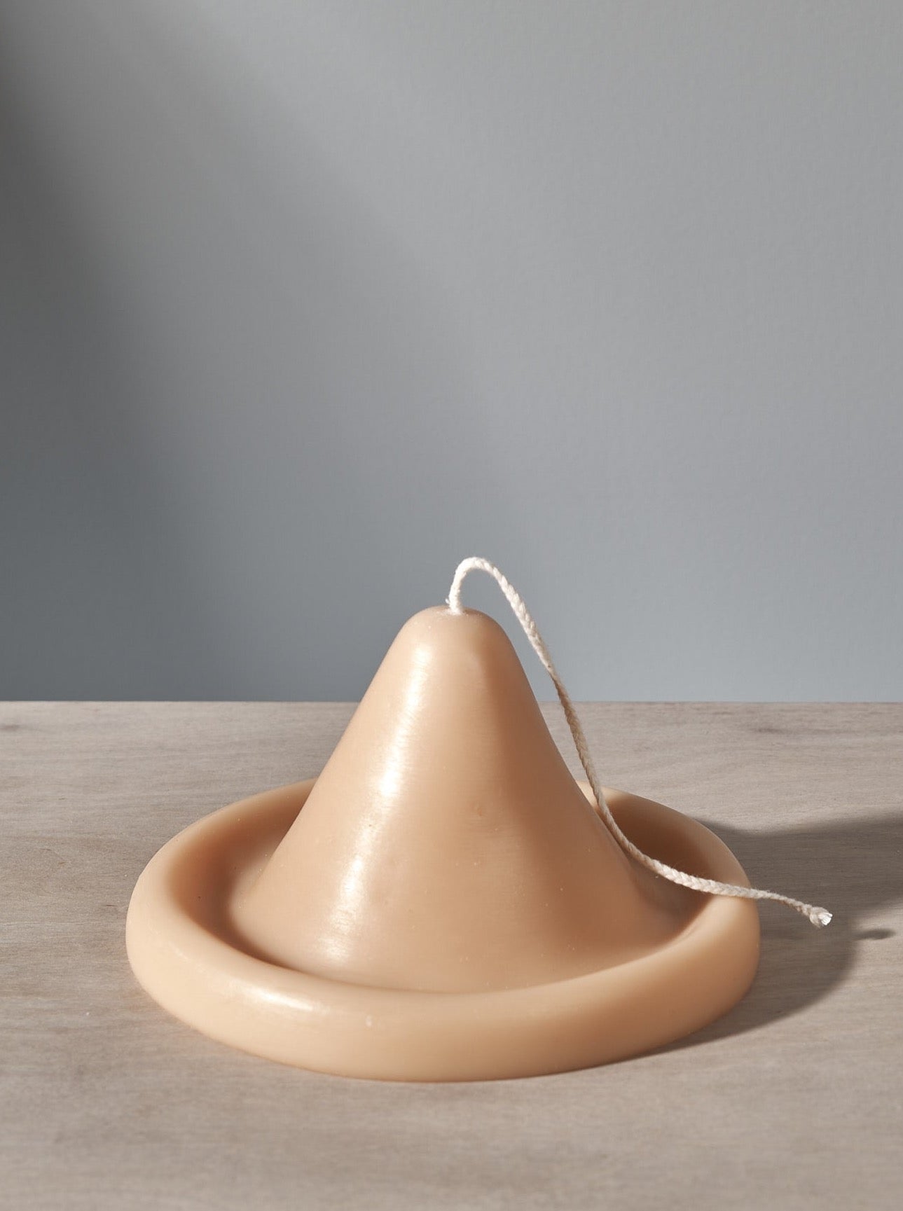 An Onno Candle shaped like a hat sitting on a table.