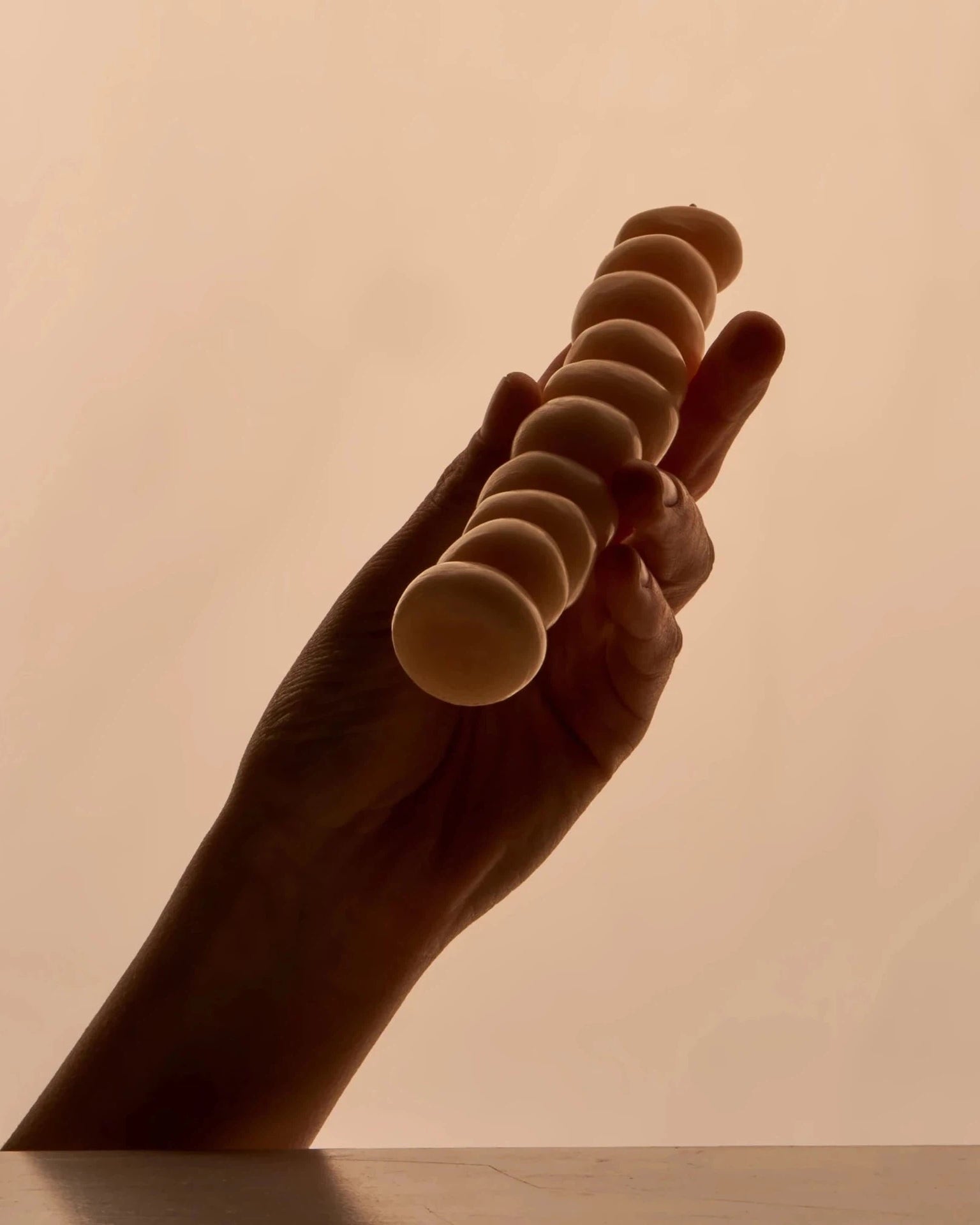 A stack of Grape Candles by ann vincent on a table with a light behind them.