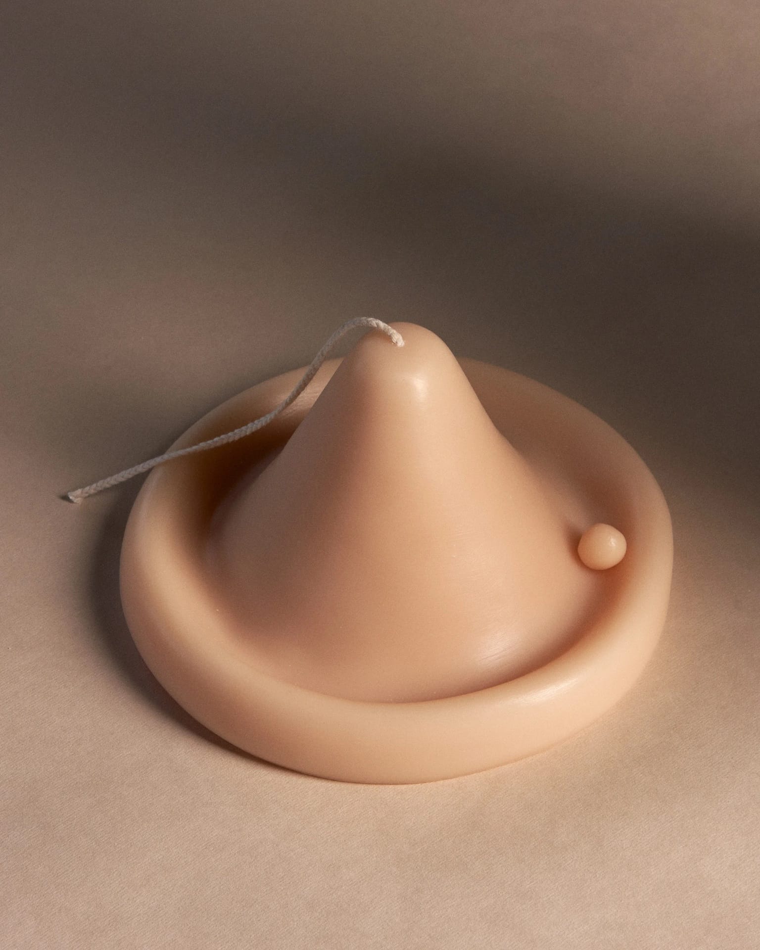 An Onno Candle shaped like a hat sitting on a table.