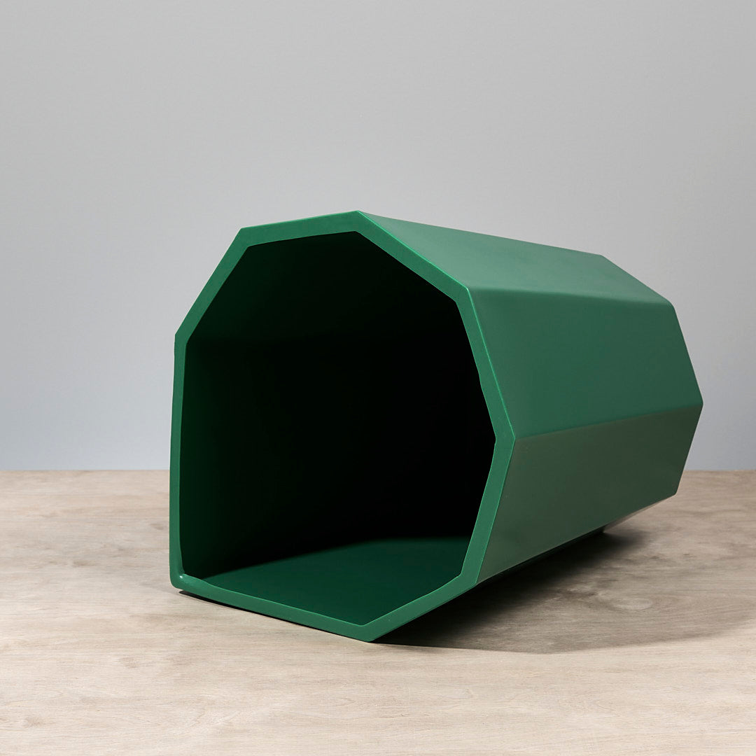 A Martino Gamper Arnold Circus Stool – Bright Green on a wooden table.