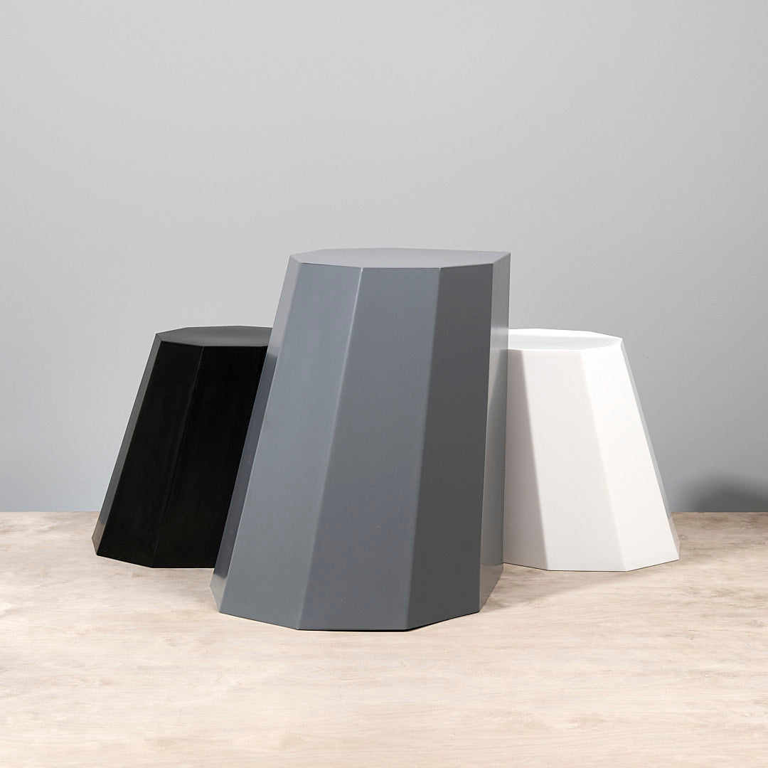 Three Arnold Circus Stools - French Grey by Martino Gamper on a wooden table.