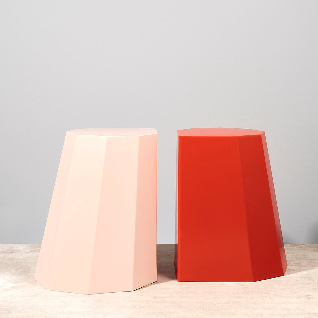 Two Martino Gamper Arnold Circus Stools - Pink on top of a table.