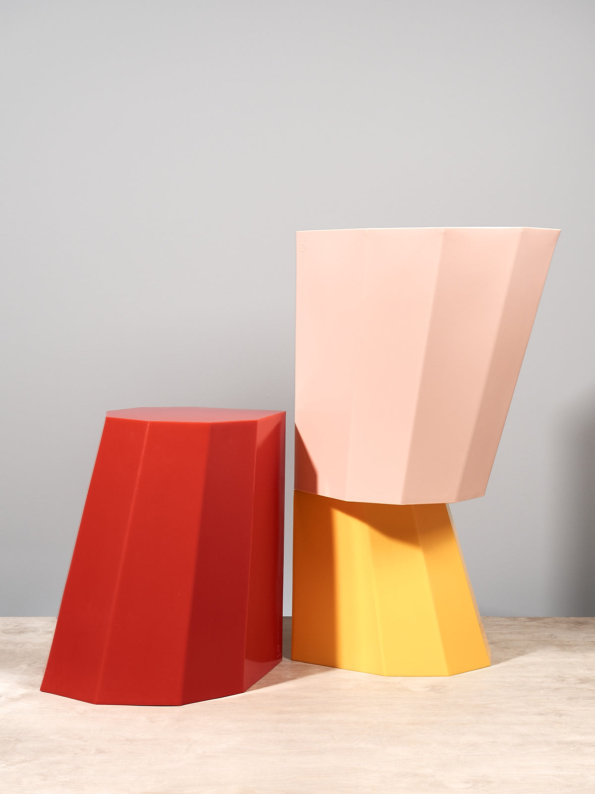 A pair of Arnold Circus Stools – Yellow by Martino Gamper on a wooden table.