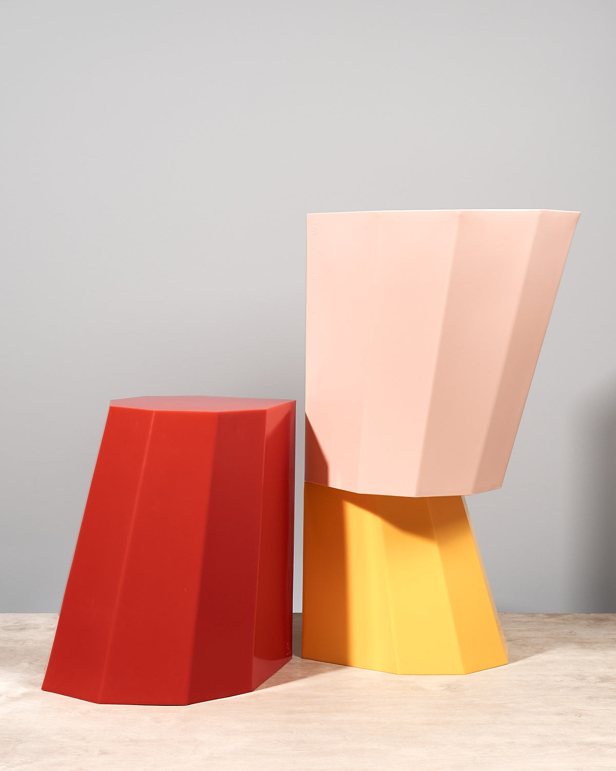 A pair of Martino Gamper Arnold Circus Stool – Pink on a wooden table.