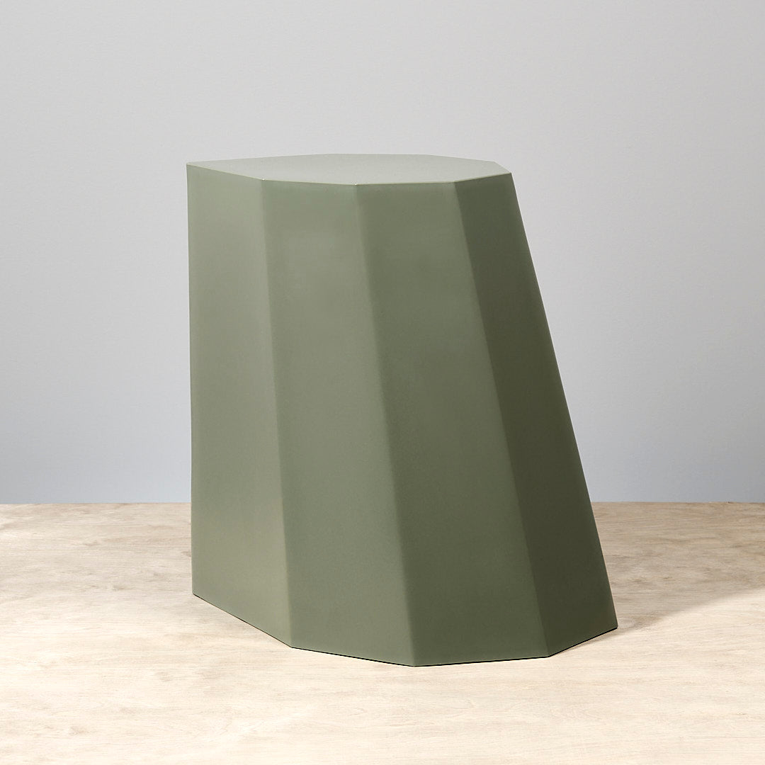 An Arnold Circus Stool – Sage by Martino Gamper on top of a wooden table.