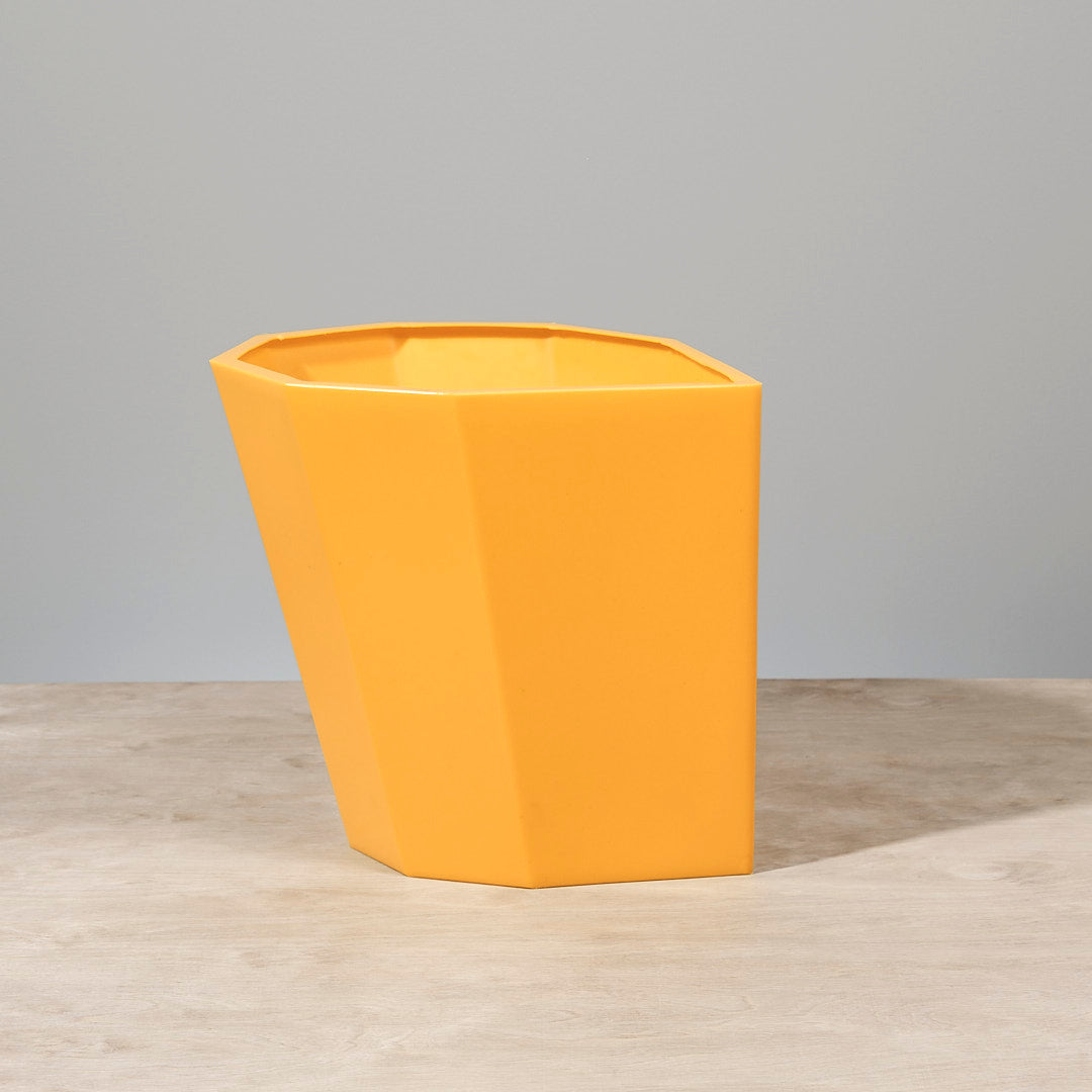 An Arnoldino Stool – Yellow, made by Martino Gamper, sitting on top of a table.