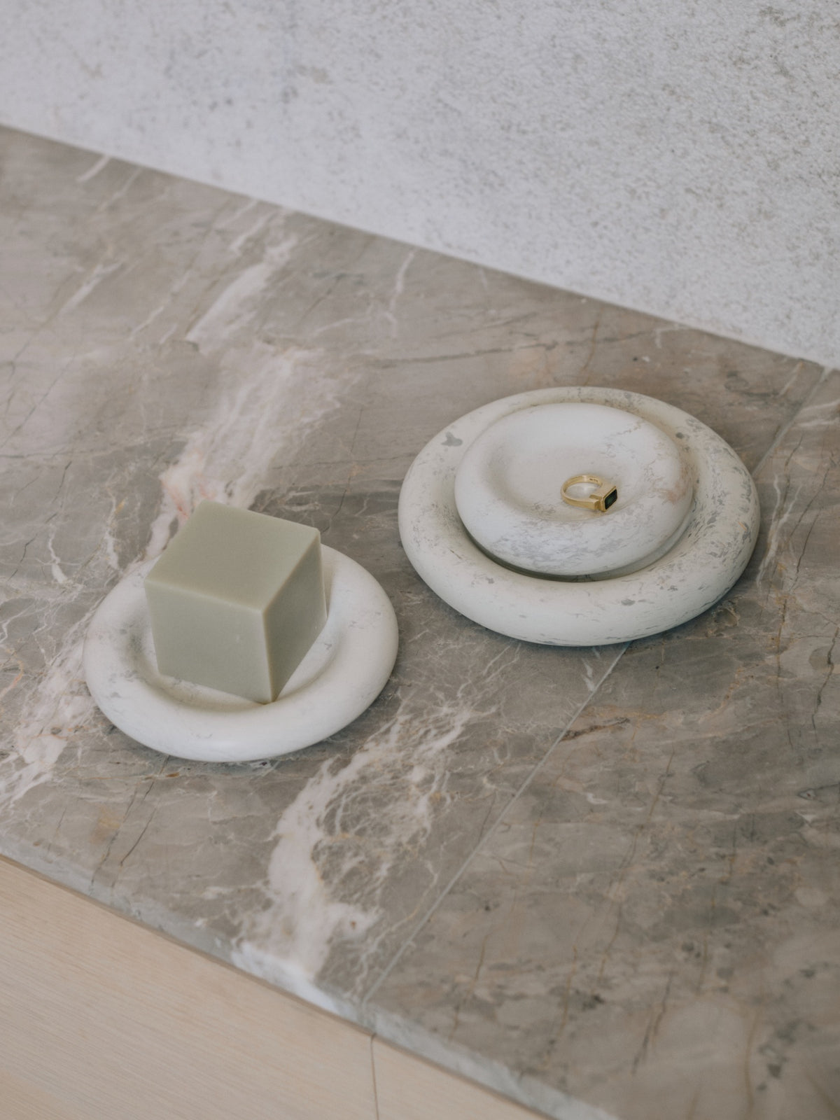 A Stacker Round Tray - Malachite by Asili on a marble counter top.