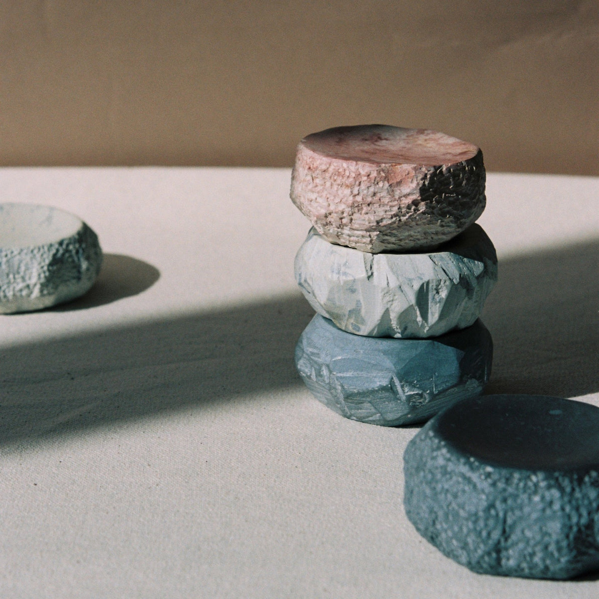 A stack of Textured Dish Set – Malachite rocks on top of a table. (Brand Name: Asili)