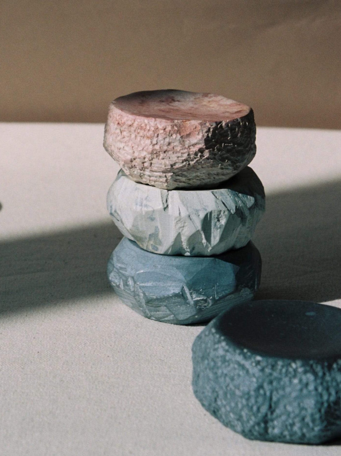 A stack of Textured Dish Set – White by Asili on top of each other.