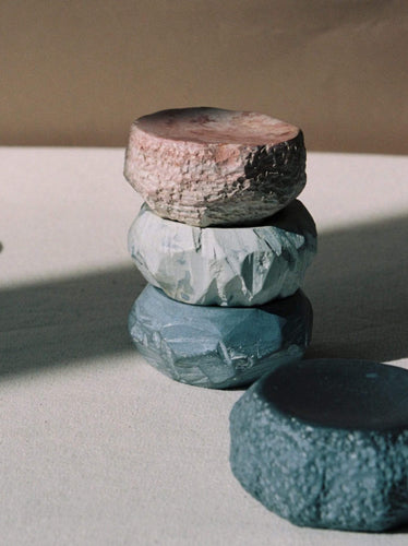 A stack of Textured Dish Set – White by Asili on top of each other.