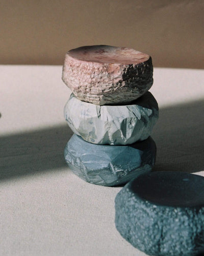 A stack of Textured Dish Set – White by Asili on top of each other.