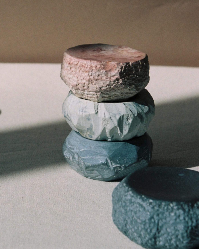 A stack of Textured Dish Set – White by Asili on top of each other.