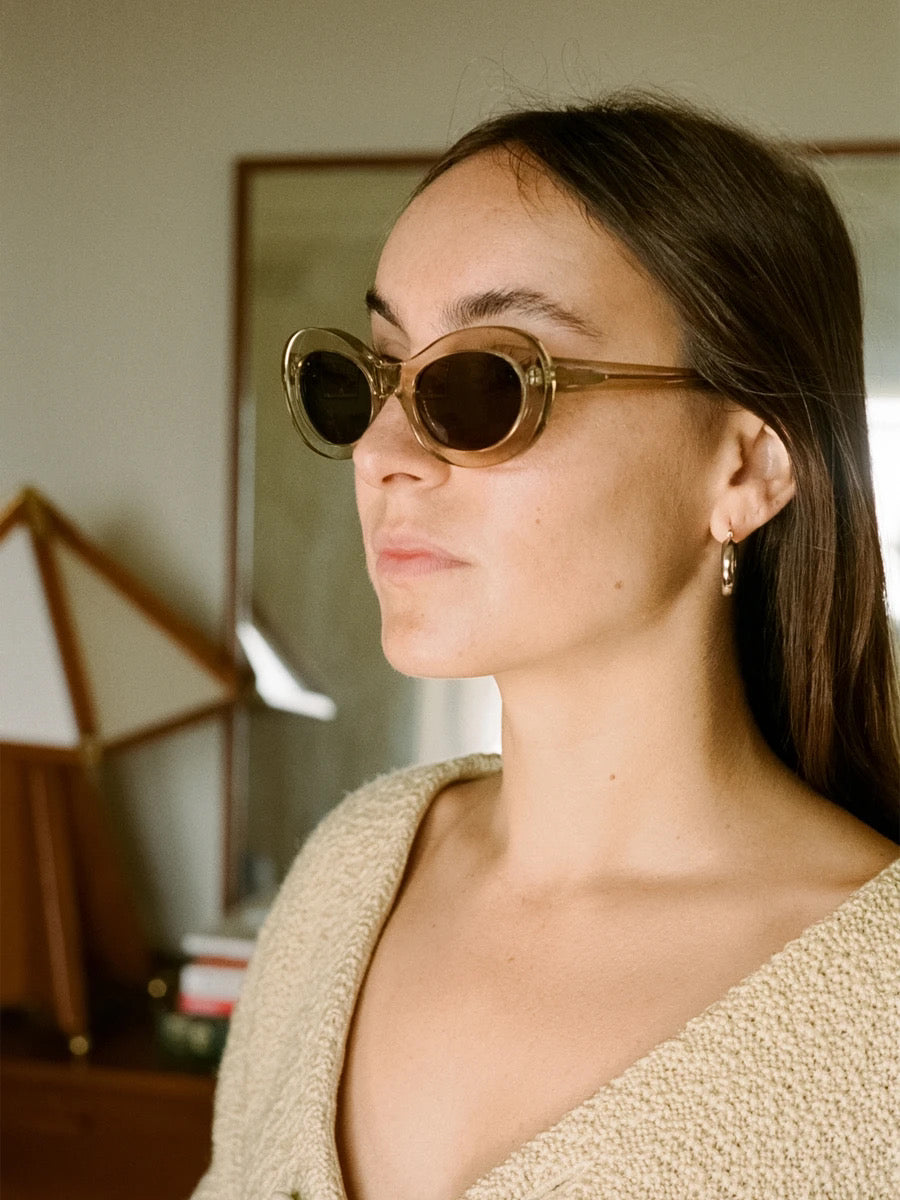 A woman wearing auór&#39;s Paloma Sunglasses - Tea in a bedroom.