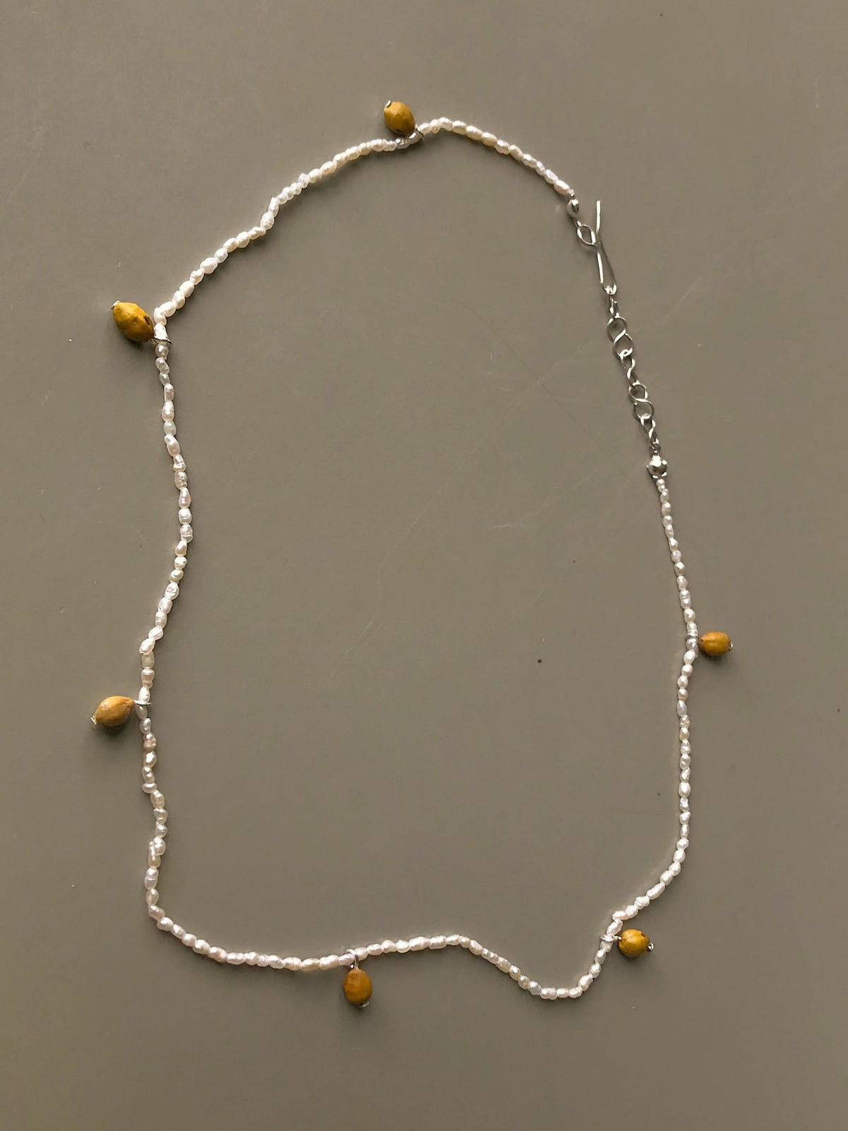 An Avara Studio Kōwhai Seed Pearl Necklace with yellow beads on it.