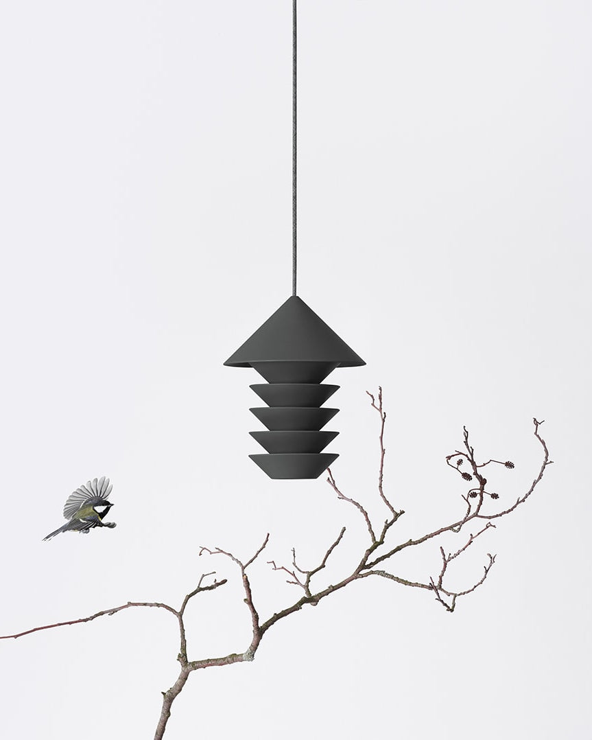A Bird Silo - Slate perched on a branch hanging from a Pidät light fixture.