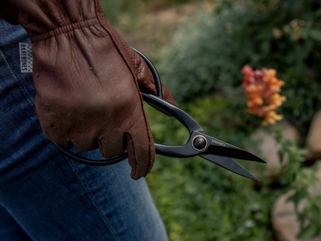 A person holding a pair of Barebones Artisan Pruning Shears.