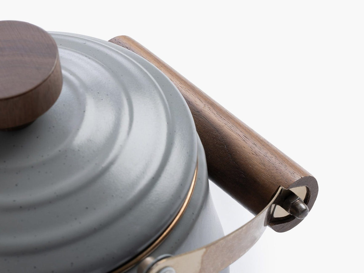 A Barebones Enamel Teapot with a wooden handle.